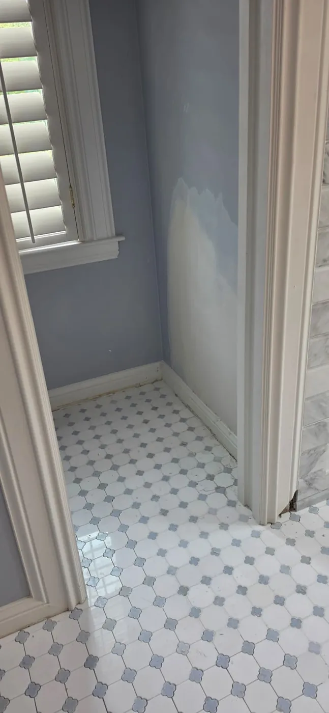 Bathroom with fresh blue-gray wall paint over a patched wall and an octagon-and-dot mosaic tile floor