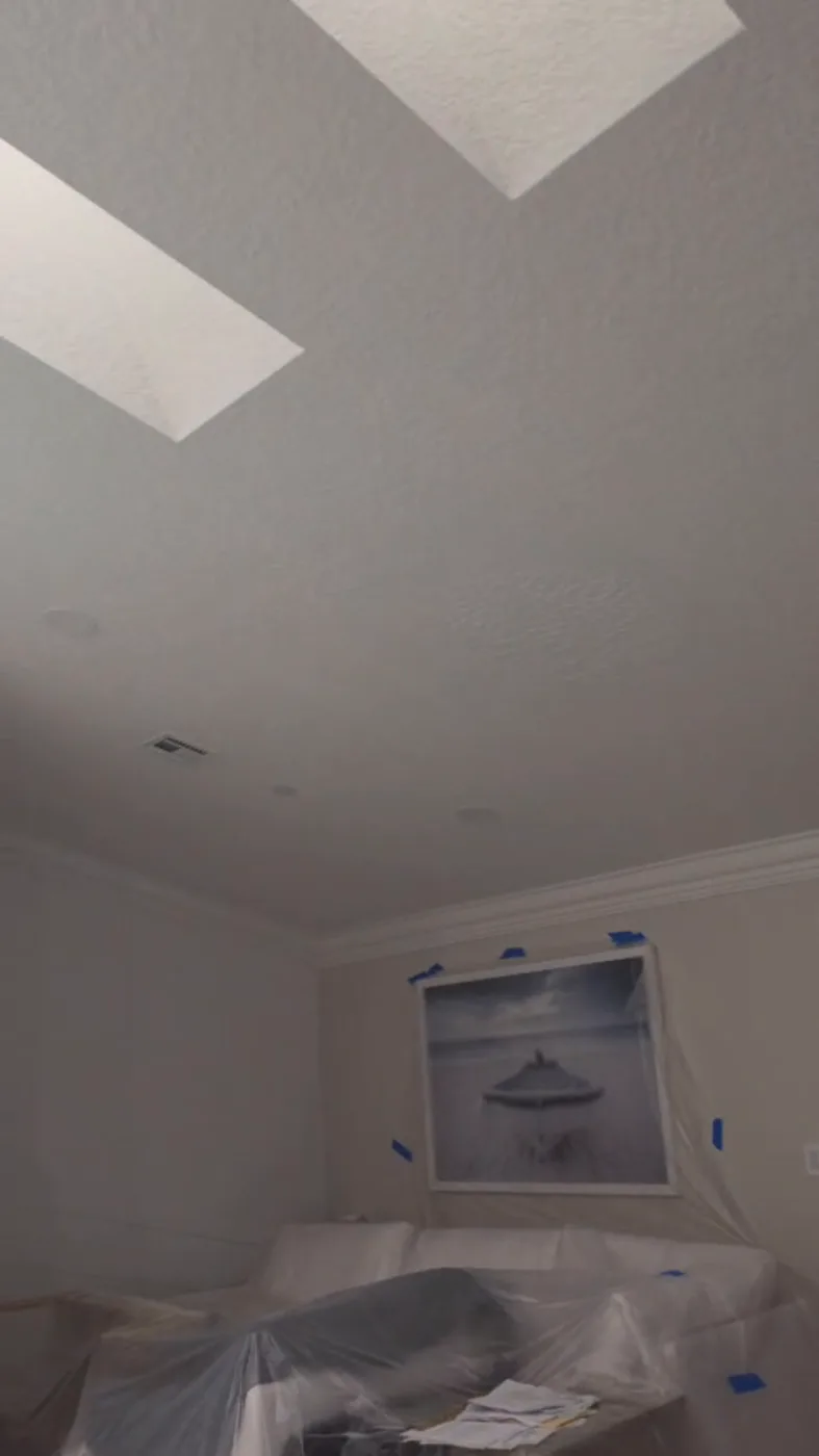 Interior with furniture draped in protective plastic and edges taped off during a job