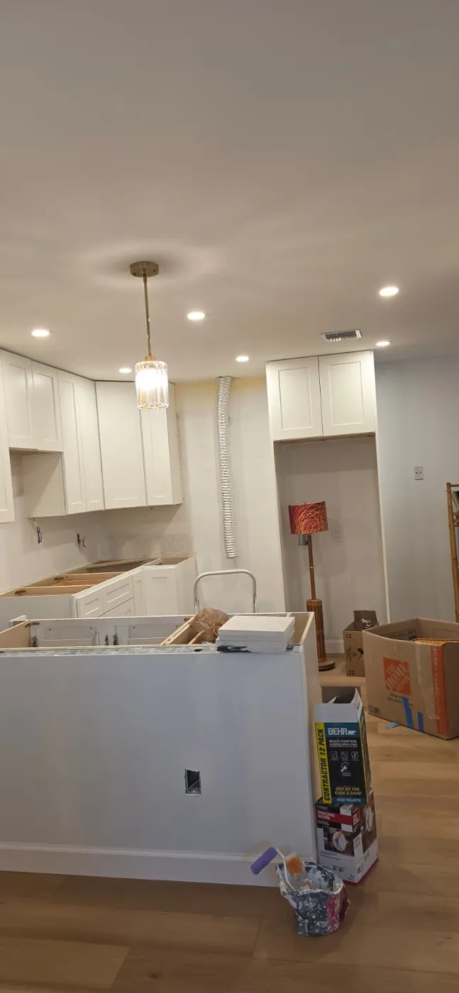 Kitchen peninsula framed and drywalled, with a glass pendant hung above